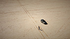 Overhead view of a person and car in desert