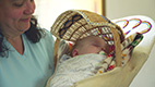 Woman hold baby in cradle board