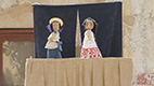 Two cloth puppets on a stage